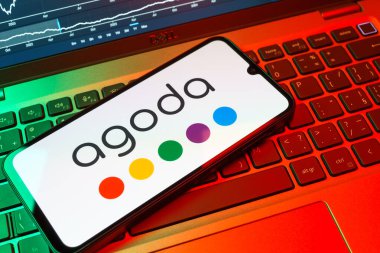 Prag, Çek Cumhuriyeti - 08 18 2025: Klavyede bir cep telefonu Agoda logosu sergiler. Agoda, otelleri ve seyahat yerlerini ayırtmak için bir platform..