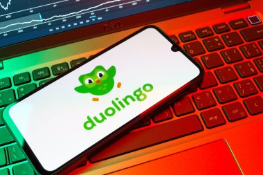 Prag, Çek Cumhuriyeti - 08 18 2025: Klavyede bir cep telefonu Duolingo logosu sergiler. Duolingo interaktif olarak dil öğrenmek için bir platformdur..