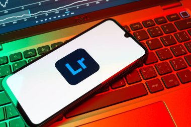 Prag, Çek Cumhuriyeti - 08 18 2025: Klavyede bir cep telefonu Lightroom logosunu gösteriyor. Lightroom fotoğraf düzenleme ve yönetim için bir yazılımdır..