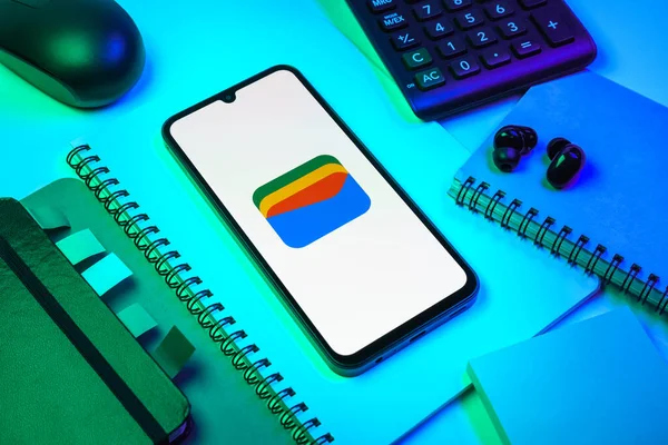 Prag, Çek Cumhuriyeti - 08 18 2025: Merkezde Google Cüzdan logosunu gösteren bir cep telefonu ile ofis malzemeleri düzenlemesi. Google Cüzdanı dijital ödeme yöntemlerini depolamak ve kullanmak için bir platformdur.
