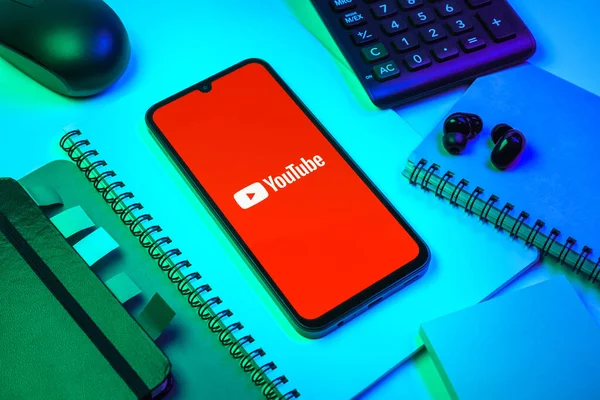 Prag, Çek Cumhuriyeti - 08 18 2025: Merkezde Youtube logosu sergilenen bir cep telefonu ile ofis malzemeleri düzenlemesi. Youtube dünya çapında videoları izlemek ve paylaşmak için bir platform.