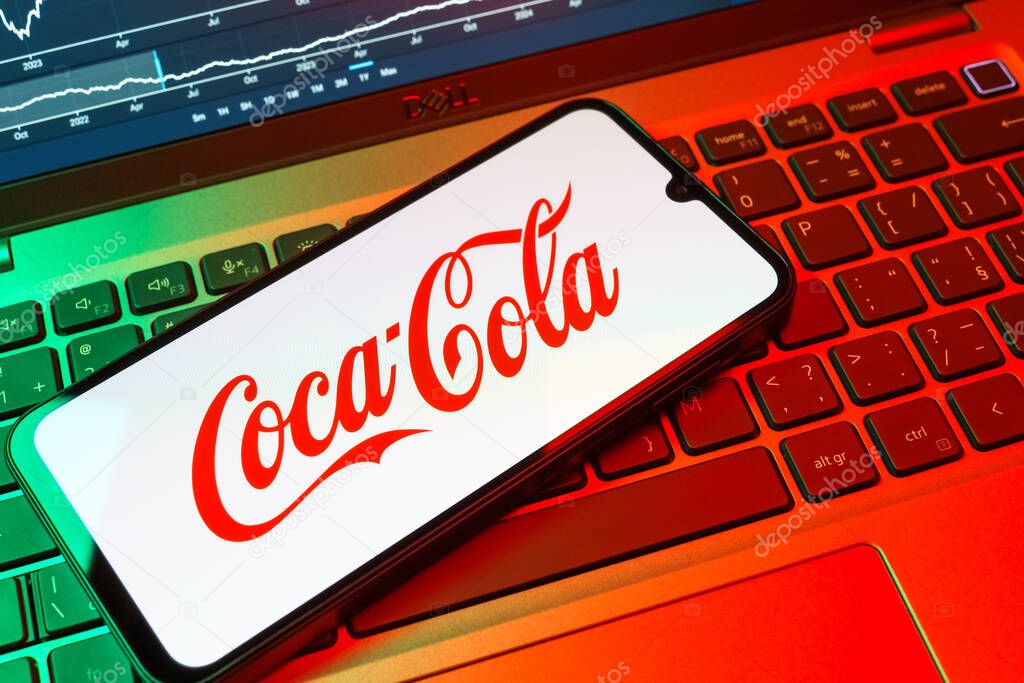Prague, Czechia - 08 18 2025: A mobile phone on a keyboard displays Coca-Cola logo. Coca-Cola is a beverage company known for its soft drinks.