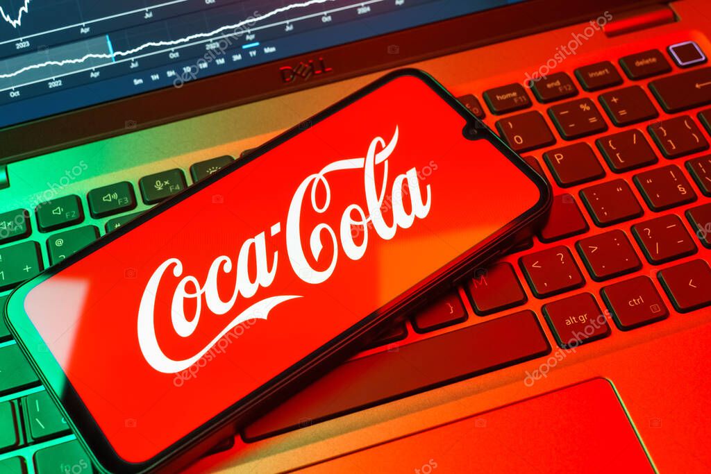 Prague, Czechia - 08 18 2025: A mobile phone on a keyboard displays Coca-Cola logo. Coca-Cola is a beverage company known for its soft drinks.