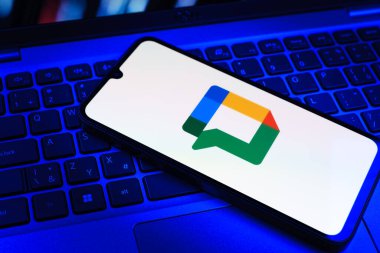 Prag, Çek Cumhuriyeti - 09 02 2025: Laptop klavyesindeki telefon renkli ışıklarla aydınlatılmış Google Chat logosunu gösteriyor. Google Chat mesajlaşma ve takım işbirliği için bir platformdur.