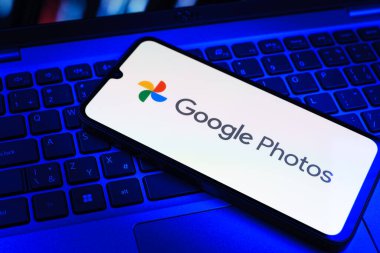Prag, Çek Cumhuriyeti - 09 02 2025: Laptop klavyesindeki telefon renkli ışık göstergeleri Google Photos logosunu gösteriyor. Google Fotoğrafları fotoğraf ve videoları saklamak ve düzenlemek için bir platformdur.