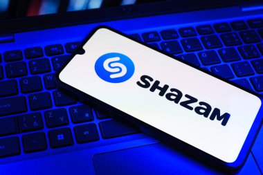 Prag, Çek Cumhuriyeti - 09 02 2025: Telefonun klavyesinde renkli ışık göstergeleri Shazam logosu var. Shazam şarkıları ve müzik parçalarını tanımlamak için bir uygulamadır.