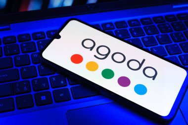 Prag, Çek Cumhuriyeti - 09 02 2025: Telefonun klavyesi renkli ışıklarla aydınlatılmış Agoda logosu gösteriyor. Agoda, otelleri ve seyahat yerlerini ayırtmak için bir platform..