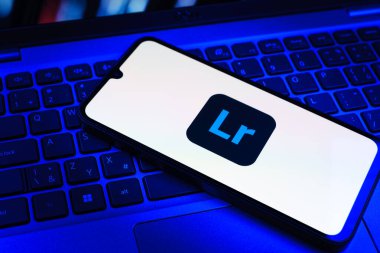 Prag, Çek Cumhuriyeti - 09 02 2025: Renkli ışık logosuyla aydınlatılan dizüstü bilgisayardaki telefon Lightroom logosunu gösteriyor. Lightroom fotoğraf düzenleme ve yönetim için bir yazılımdır..