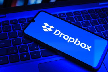 Prag, Çek Cumhuriyeti - 09 02 2025: Telefonun klavyesi renkli ışık gösteren Dropbox logosuyla aydınlatıldı. Dropbox bulut depolama ve dosya paylaşımı için bir platformdur.