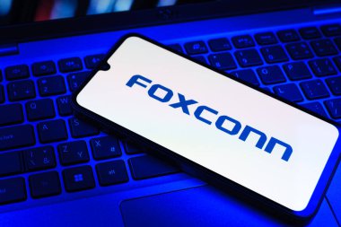 Prag, Çek Cumhuriyeti - 09 02 2025: Telefon dizüstü bilgisayarda renkli ışık tarafından aydınlatılmış Foxconn logosu. Foxconn elektronik ve parça üreten bir şirket..