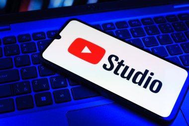 Prag, Çek Cumhuriyeti - 09 02 2025: Renkli ışık tarafından yakılan dizüstü bilgisayardaki telefon Youtube Studio logosunu gösteriyor. Youtube Studio YouTube kanallarını yönetmek ve analiz etmek için bir platformdur.