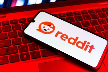 Prag, Çek Cumhuriyeti - 09 02 2025: Renkli ışık tarafından yakılan dizüstü bilgisayardaki telefon Reddit logosunu gösteriyor. Reddit tartışma, haber ve toplum içeriği için bir platformdur.