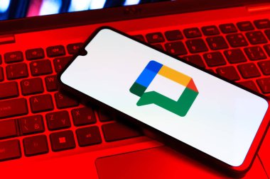 Prag, Çek Cumhuriyeti - 09 02 2025: Laptop klavyesindeki telefon renkli ışıklarla aydınlatılmış Google Chat logosunu gösteriyor. Google Chat mesajlaşma ve takım işbirliği için bir platformdur.