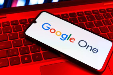 Prag, Çek Cumhuriyeti - 09 02 2025: Renkli ışık tarafından yakılan dizüstü bilgisayardaki telefon Google One logosunu gösteriyor. Google 1 bulut depolama ve abonelik hizmetleri için bir platformdur.
