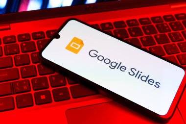 Prag, Çek Cumhuriyeti - 09 02 2025: Laptop klavyesindeki telefon renkli ışık göstergesi Google Slides logosunu gösteriyor. Google Slides sunumlar ve slayt gösterileri oluşturmak için bir platformdur.