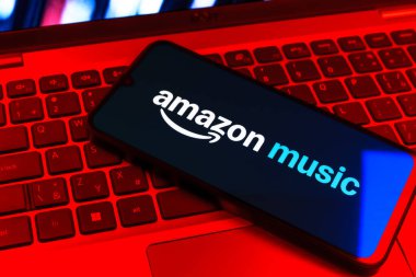 Prag, Çek Cumhuriyeti - 09 02 2025: Renkli ışık tarafından aydınlatılan dizüstü bilgisayardaki telefon Amazon Müzik logosunu gösteriyor. Amazon Müzik müzik müzik için bir platformdur..