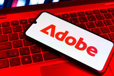 Prag, Çek Cumhuriyeti - 09 02 2025: Telefonun klavyesinde renkli ışık gösterileri Adobe logosu var. Adobe yaratıcı araçlar ve hizmetler sunan bir yazılım şirketidir..