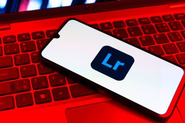 Prag, Çek Cumhuriyeti - 09 02 2025: Renkli ışık logosuyla aydınlatılan dizüstü bilgisayardaki telefon Lightroom logosunu gösteriyor. Lightroom fotoğraf düzenleme ve yönetim için bir yazılımdır..