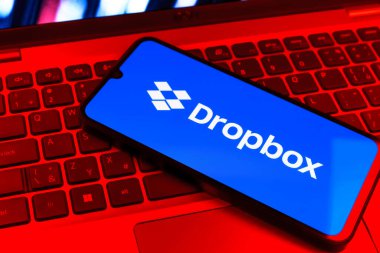 Prag, Çek Cumhuriyeti - 09 02 2025: Telefonun klavyesi renkli ışık gösteren Dropbox logosuyla aydınlatıldı. Dropbox bulut depolama ve dosya paylaşımı için bir platformdur.