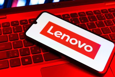 Prag, Çek Cumhuriyeti - 09 02 2025: Renkli ışıklarla aydınlatılmış dizüstü bilgisayardaki telefon Lenovo logosunu gösteriyor. Lenovo bilgisayar ve elektronik üreten bir teknoloji şirketidir..