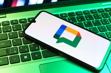 Prag, Çek Cumhuriyeti - 09 02 2025: Laptop klavyesindeki telefon renkli ışıklarla aydınlatılmış Google Chat logosunu gösteriyor. Google Chat mesajlaşma ve takım işbirliği için bir platformdur.