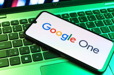 Prag, Çek Cumhuriyeti - 09 02 2025: Renkli ışık tarafından yakılan dizüstü bilgisayardaki telefon Google One logosunu gösteriyor. Google 1 bulut depolama ve abonelik hizmetleri için bir platformdur.