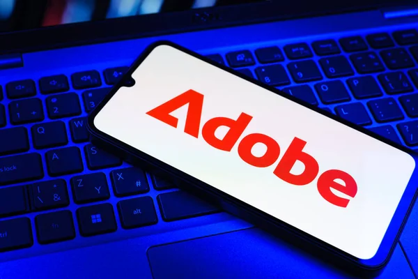 Prag, Çek Cumhuriyeti - 09 02 2025: Telefonun klavyesinde renkli ışık gösterileri Adobe logosu var. Adobe yaratıcı araçlar ve hizmetler sunan bir yazılım şirketidir..