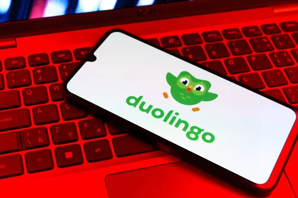 Prag, Çek Cumhuriyeti - 09 02 2025: Diz üstü bilgisayardaki telefon renkli ışık Duolingo logosunu gösteriyor. Duolingo interaktif olarak dil öğrenmek için bir platformdur..