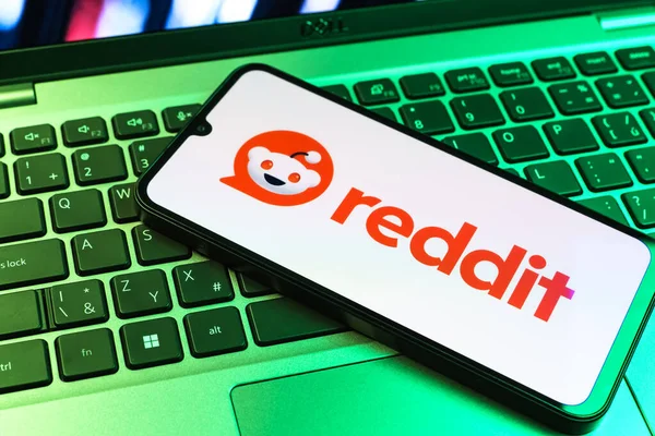 Prag, Çek Cumhuriyeti - 09 02 2025: Renkli ışık tarafından yakılan dizüstü bilgisayardaki telefon Reddit logosunu gösteriyor. Reddit tartışma, haber ve toplum içeriği için bir platformdur.