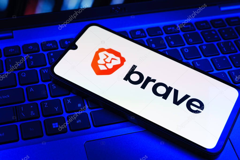 Prague, Czechia - 09 02 2025: Phone on laptop keyboard lit by colored light shows Brave logo. Brave is a web browser focused on privacy and speed.