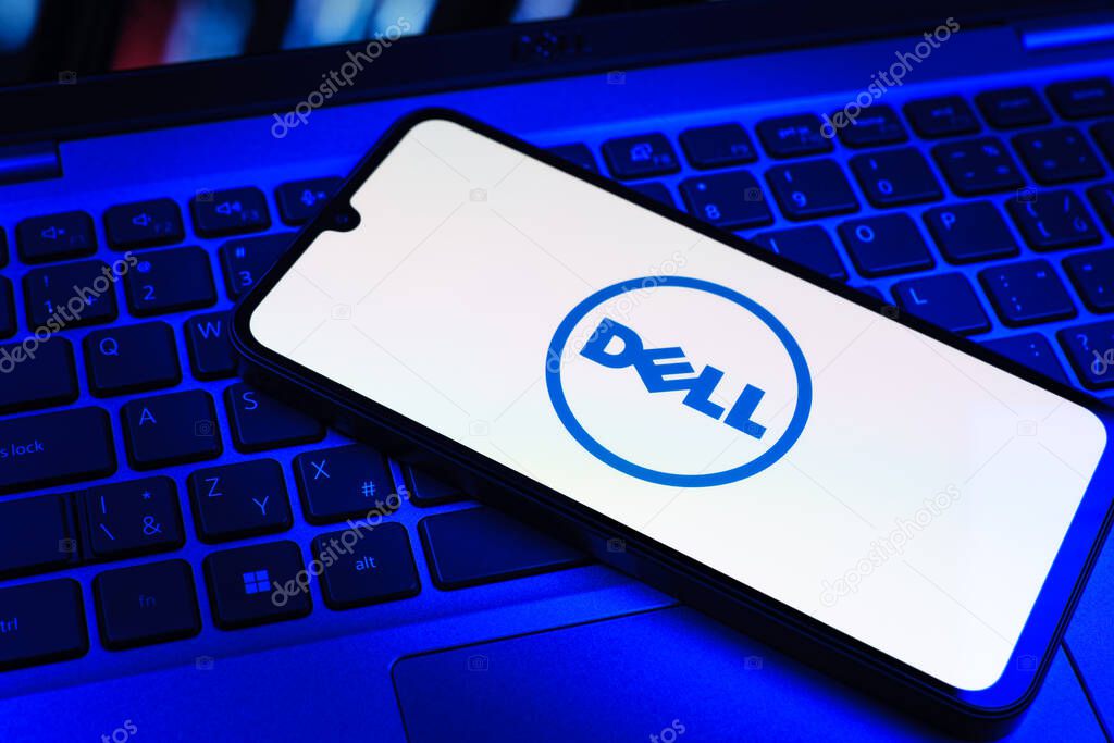 Prague, Czechia - 09 02 2025: Phone on laptop keyboard lit by colored light shows Dell logo. Dell is a technology company producing computers and IT solutions.