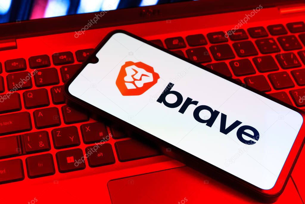 Prague, Czechia - 09 02 2025: Phone on laptop keyboard lit by colored light shows Brave logo. Brave is a web browser focused on privacy and speed.