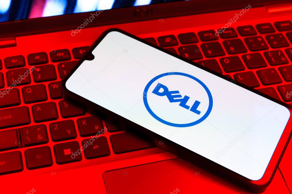 Prague, Czechia - 09 02 2025: Phone on laptop keyboard lit by colored light shows Dell logo. Dell is a technology company producing computers and IT solutions.