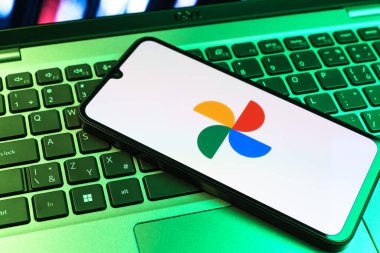 Prag, Çek Cumhuriyeti - 09 02 2025: Laptop klavyesindeki telefon renkli ışık göstergeleri Google Photos logosunu gösteriyor. Google Fotoğrafları fotoğraf ve videoları saklamak ve düzenlemek için bir platformdur.