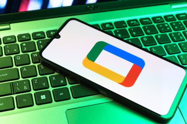 Prag, Çek Cumhuriyeti - 09 02 2025: Laptop klavyesindeki telefon renkli ışık gösterileri Google TV logosunu gösteriyor. Google TV film, program ve uygulamalar için bir platformdur..