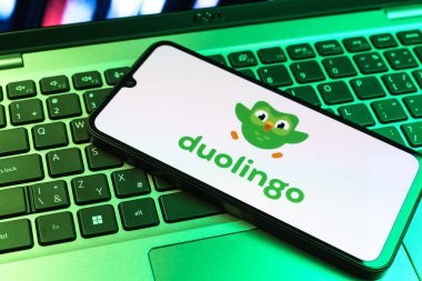 Prag, Çek Cumhuriyeti - 09 02 2025: Diz üstü bilgisayardaki telefon renkli ışık Duolingo logosunu gösteriyor. Duolingo interaktif olarak dil öğrenmek için bir platformdur..