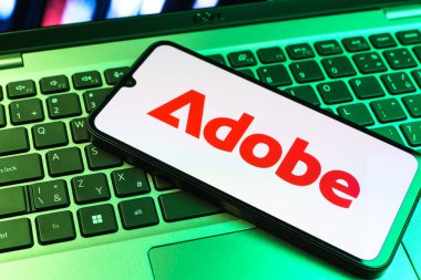 Prag, Çek Cumhuriyeti - 09 02 2025: Telefonun klavyesinde renkli ışık gösterileri Adobe logosu var. Adobe yaratıcı araçlar ve hizmetler sunan bir yazılım şirketidir..