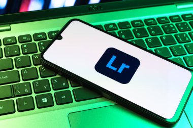 Prag, Çek Cumhuriyeti - 09 02 2025: Renkli ışık logosuyla aydınlatılan dizüstü bilgisayardaki telefon Lightroom logosunu gösteriyor. Lightroom fotoğraf düzenleme ve yönetim için bir yazılımdır..