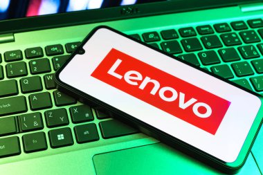 Prag, Çek Cumhuriyeti - 09 02 2025: Renkli ışıklarla aydınlatılmış dizüstü bilgisayardaki telefon Lenovo logosunu gösteriyor. Lenovo bilgisayar ve elektronik üreten bir teknoloji şirketidir..