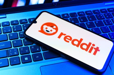 Prag, Çek Cumhuriyeti - 09 02 2025: Renkli ışık tarafından yakılan dizüstü bilgisayardaki telefon Reddit logosunu gösteriyor. Reddit tartışma, haber ve toplum içeriği için bir platformdur.