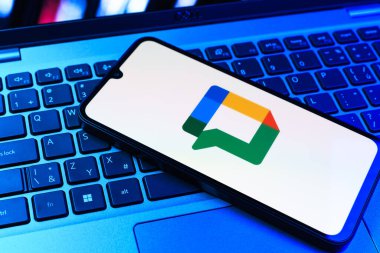 Prag, Çek Cumhuriyeti - 09 02 2025: Laptop klavyesindeki telefon renkli ışıklarla aydınlatılmış Google Chat logosunu gösteriyor. Google Chat mesajlaşma ve takım işbirliği için bir platformdur.