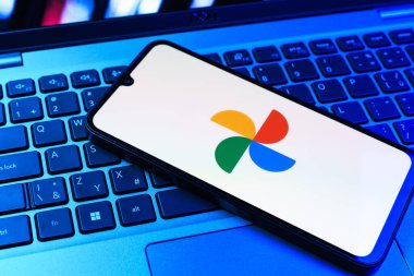 Prag, Çek Cumhuriyeti - 09 02 2025: Laptop klavyesindeki telefon renkli ışık göstergeleri Google Photos logosunu gösteriyor. Google Fotoğrafları fotoğraf ve videoları saklamak ve düzenlemek için bir platformdur.