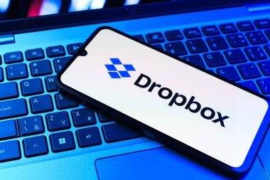 Prag, Çek Cumhuriyeti - 09 02 2025: Telefonun klavyesi renkli ışık gösteren Dropbox logosuyla aydınlatıldı. Dropbox bulut depolama ve dosya paylaşımı için bir platformdur.