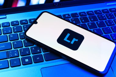 Prag, Çek Cumhuriyeti - 09 02 2025: Renkli ışık logosuyla aydınlatılan dizüstü bilgisayardaki telefon Lightroom logosunu gösteriyor. Lightroom fotoğraf düzenleme ve yönetim için bir yazılımdır..