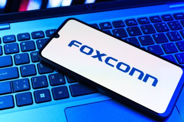 Prag, Çek Cumhuriyeti - 09 02 2025: Telefon dizüstü bilgisayarda renkli ışık tarafından aydınlatılmış Foxconn logosu. Foxconn elektronik ve parça üreten bir şirket..