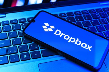 Prag, Çek Cumhuriyeti - 09 02 2025: Telefonun klavyesi renkli ışık gösteren Dropbox logosuyla aydınlatıldı. Dropbox bulut depolama ve dosya paylaşımı için bir platformdur.