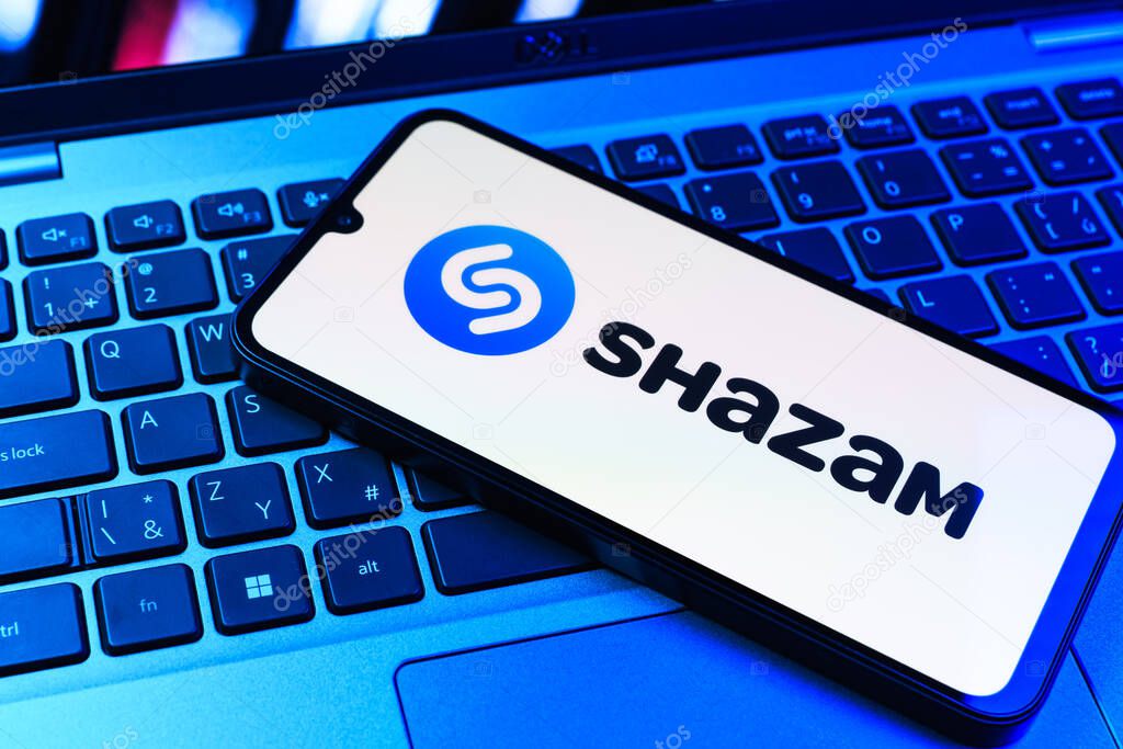 Prague, Czechia - 09 02 2025: Phone on laptop keyboard lit by colored light shows Shazam logo. Shazam is an app for identifying songs and music tracks.