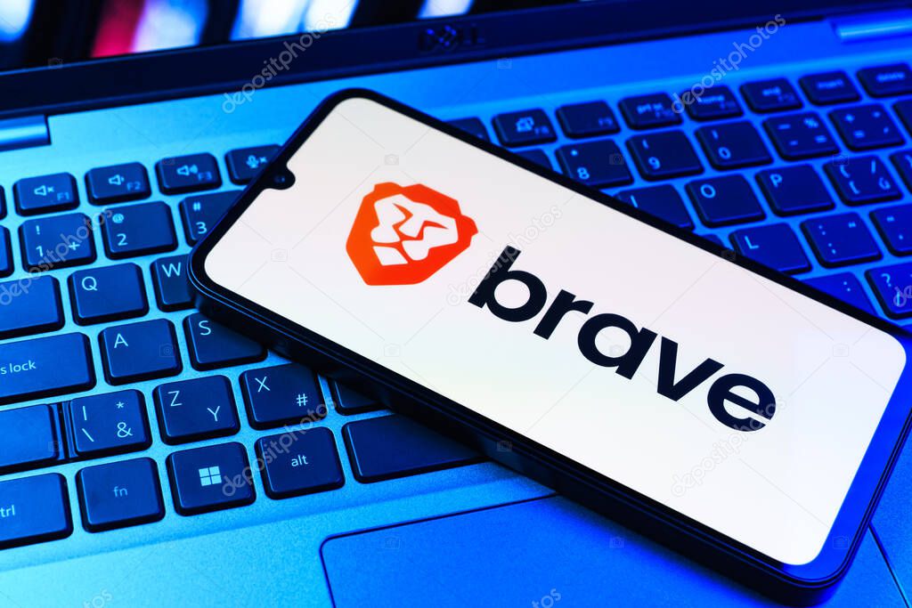 Prague, Czechia - 09 02 2025: Phone on laptop keyboard lit by colored light shows Brave logo. Brave is a web browser focused on privacy and speed.