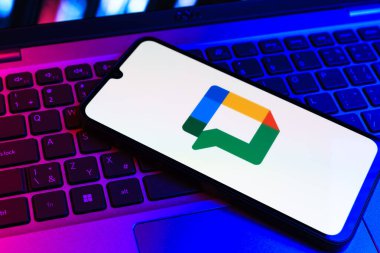 Prag, Çek Cumhuriyeti - 09 02 2025: Laptop klavyesindeki telefon renkli ışıklarla aydınlatılmış Google Chat logosunu gösteriyor. Google Chat mesajlaşma ve takım işbirliği için bir platformdur.