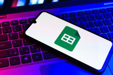 Prag, Çek Cumhuriyeti - 09 02 2025: Laptop klavyesindeki telefon renkli ışık göstergeleri Google Sheets logosunu gösteriyor. Google Sayfalar tablo oluşturmak ve yönetmek için bir platformdur.